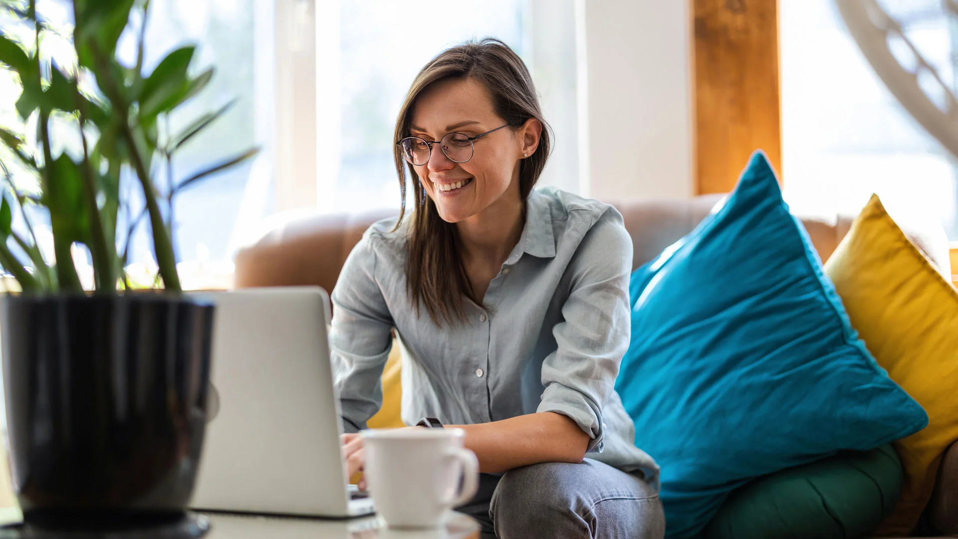 Young woman writing a coverr letter on a laptop at home.