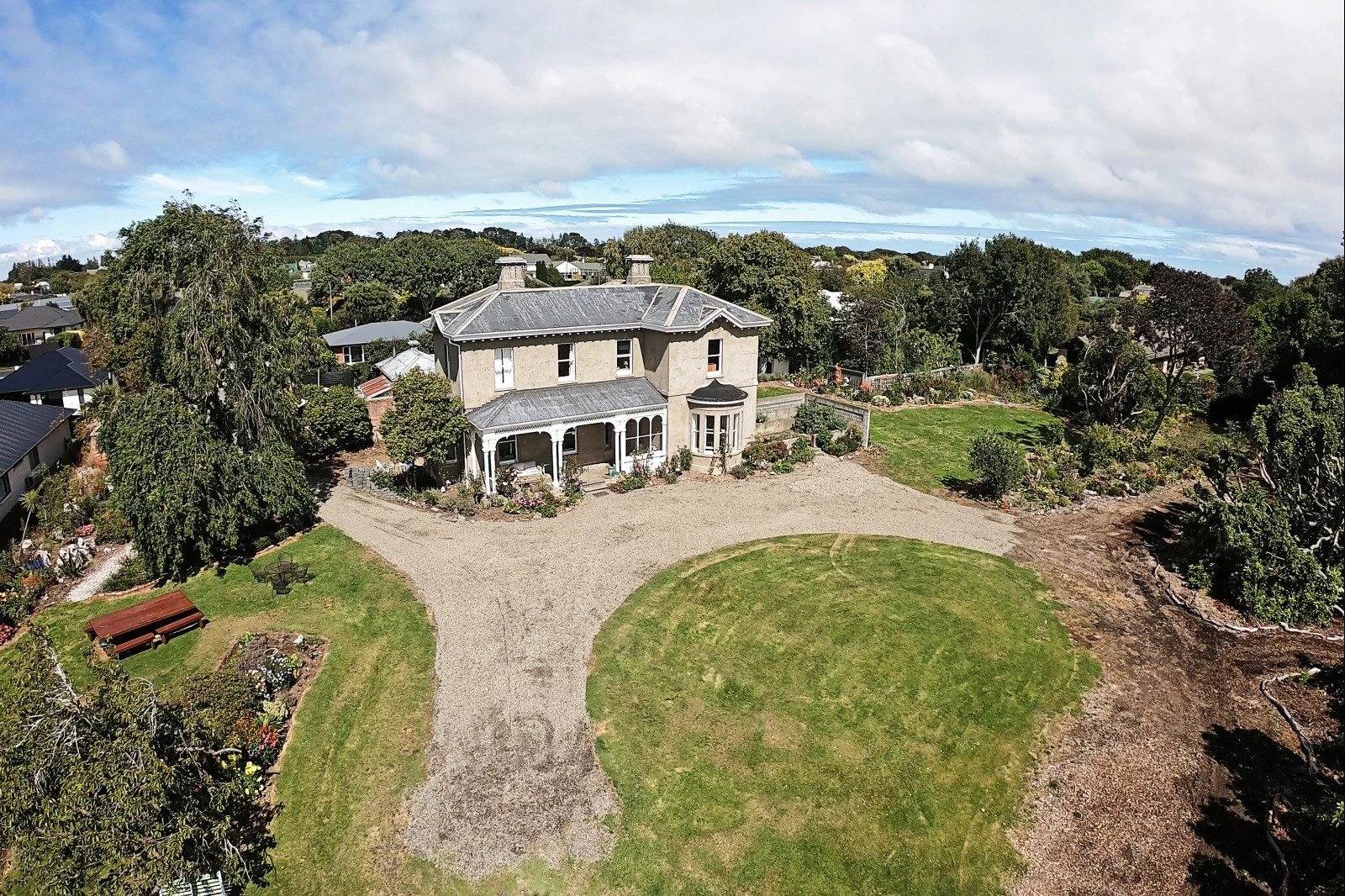 A white period house sits at the end of a gravel path.