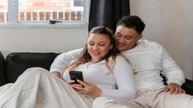 Couple sitting on the sofa looking at their phone