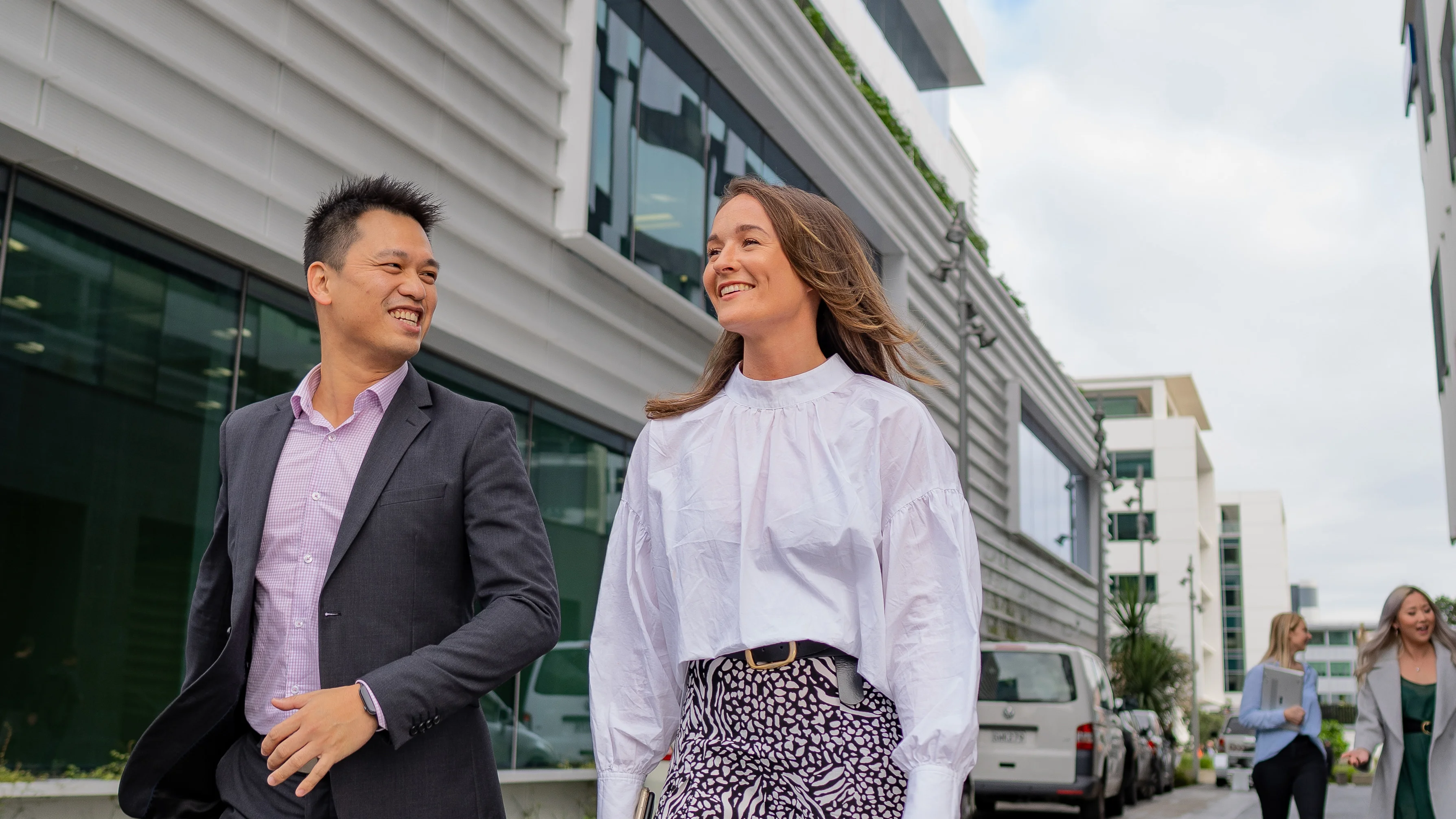 Two employees walking, smiling.