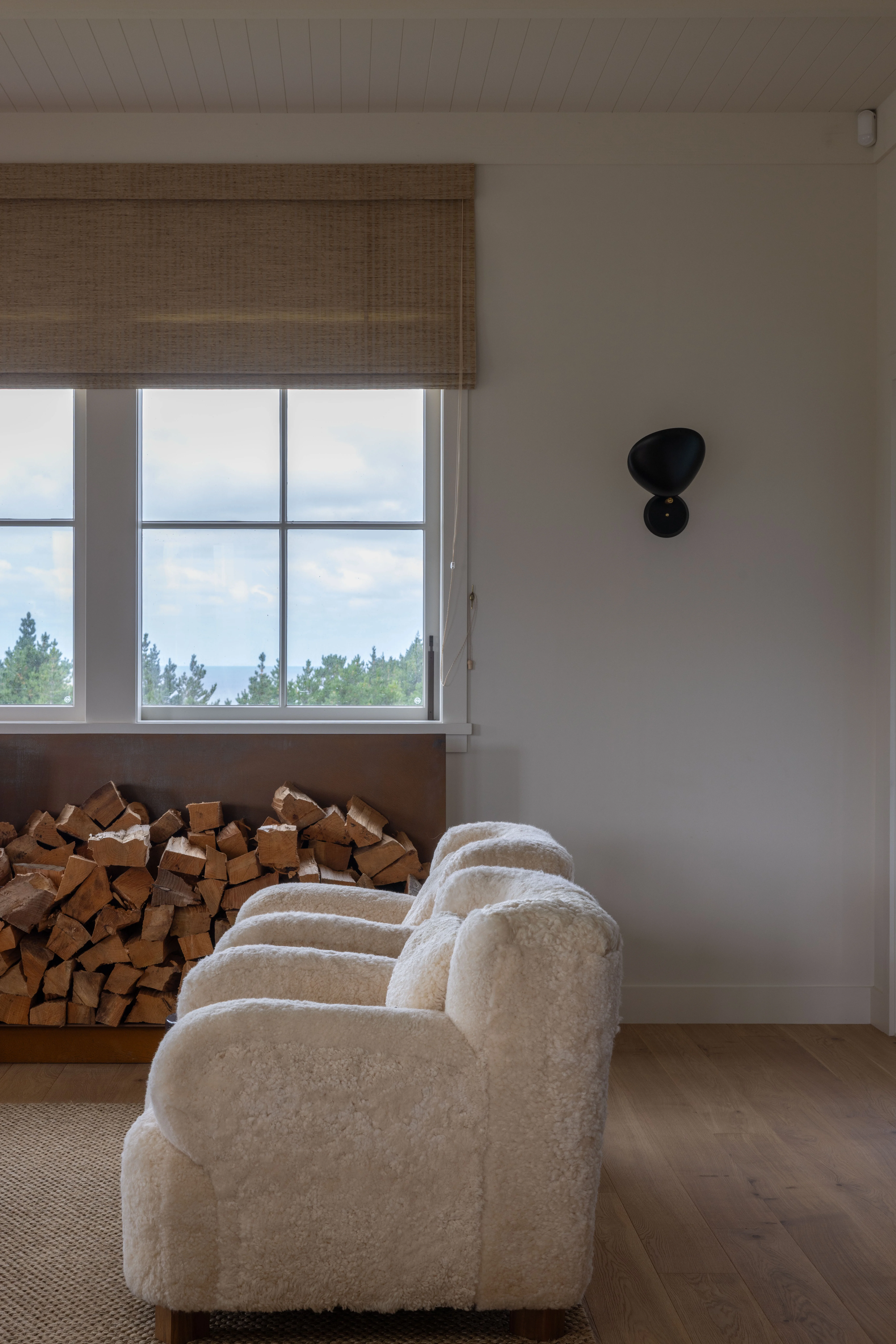 Big Bertha sheepskin chairs, custom-made at Little & Fox, are woolly wonders in the living room. A Cobra wall lamp, designed by Greta Magnusson Grossman in the 1950s and now made by Gubi, was chosen for this corner and Peter Meyer Urban Natural Weave roman blinds draw down to make the space even cosier.