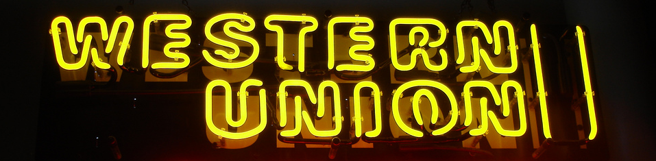 neon yellow "western Union" sign on a black back drop