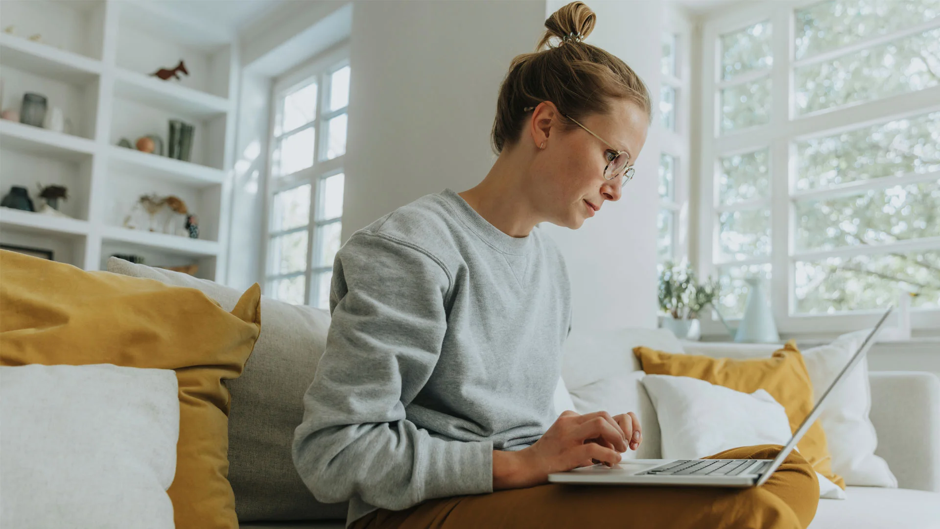 Woman writing her CV at home on a laptop.