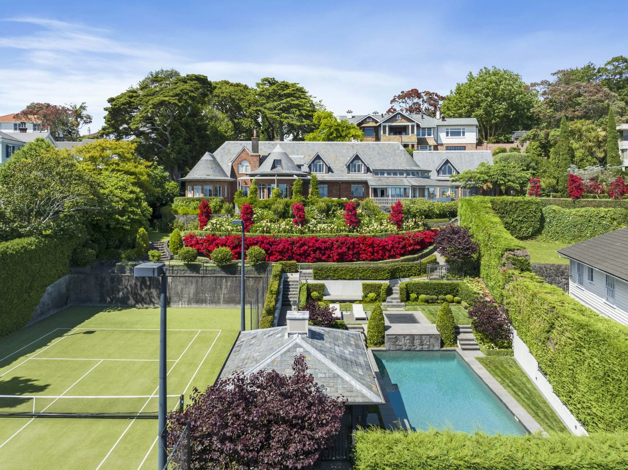 Grand estate on Remuera Road, Auckland, one of the most expensive houses in New Zealand, featuring landscaped gardens, a tennis court, and luxury pool.