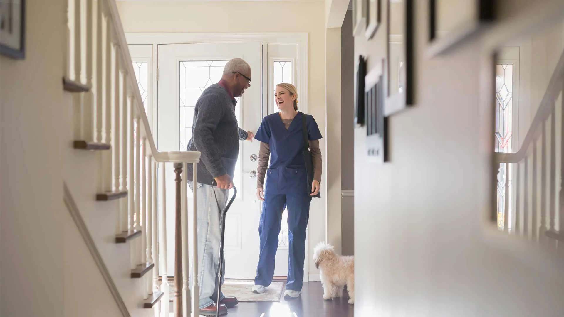 Healthcare assistant laughing with a patient.