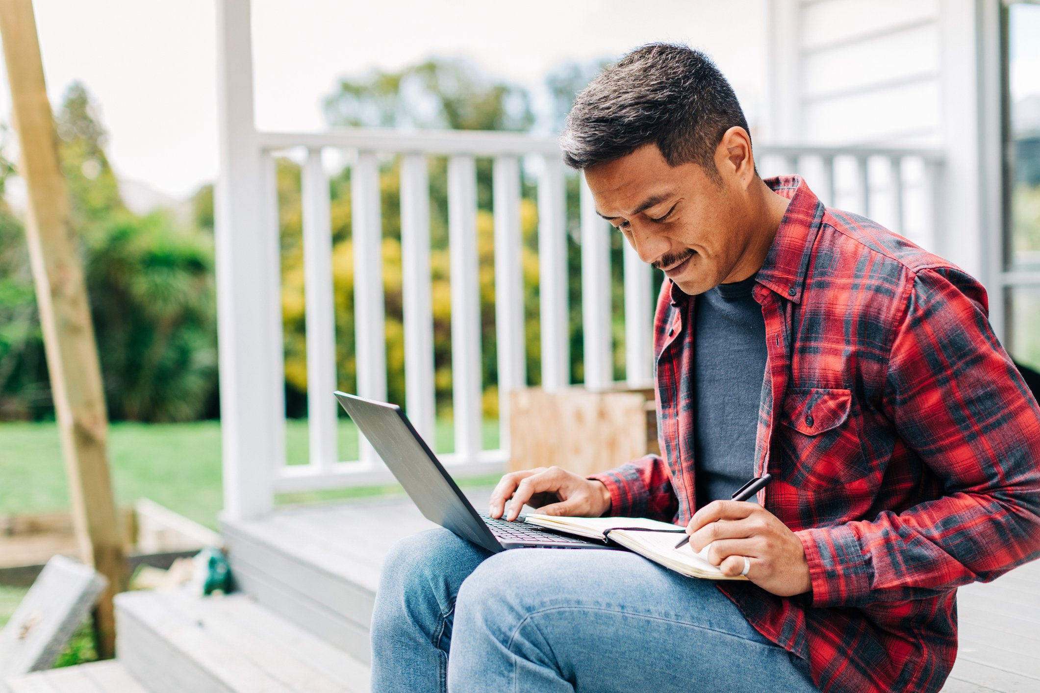 Young male sitting outside on laptop