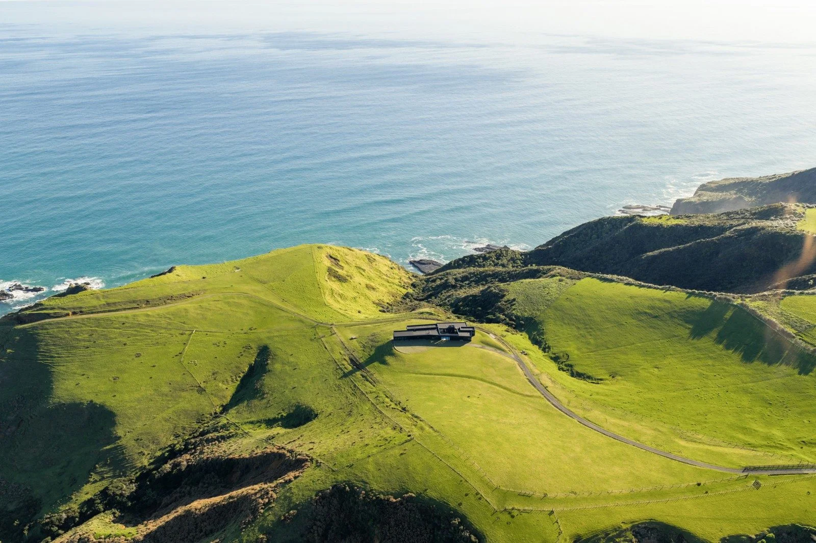 Aerial view of Parihoa Estate on Auckland’s wild west coast, one of the most expensive houses in New Zealand, set on dramatic clifftop farmland overlooking the Tasman Sea.