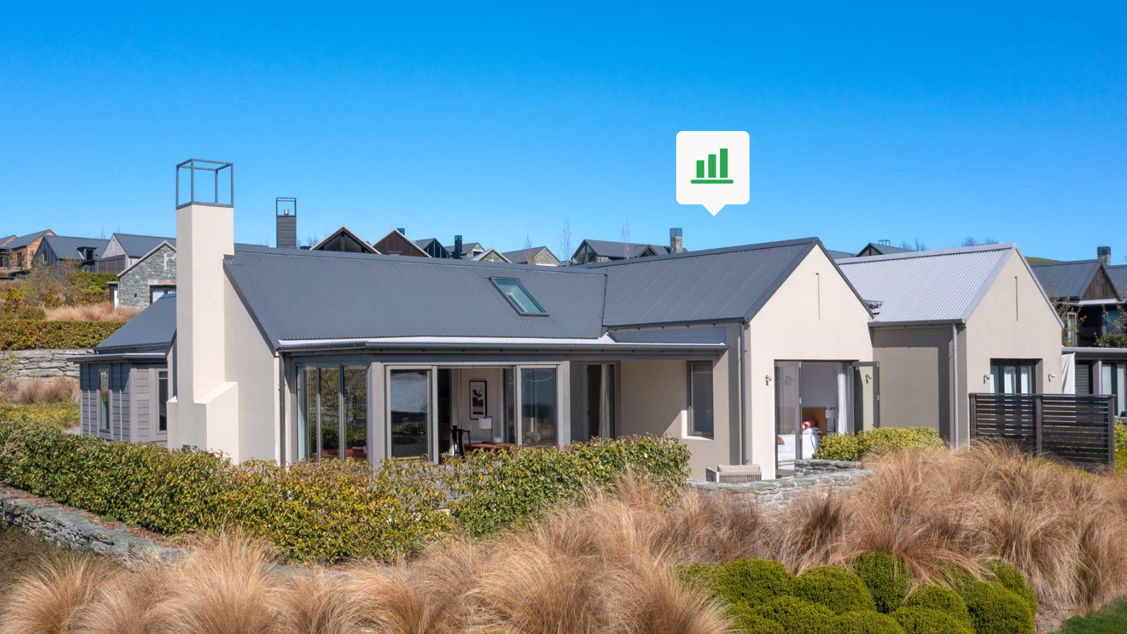 Grey home with grey roof, with grasses surrounding the property