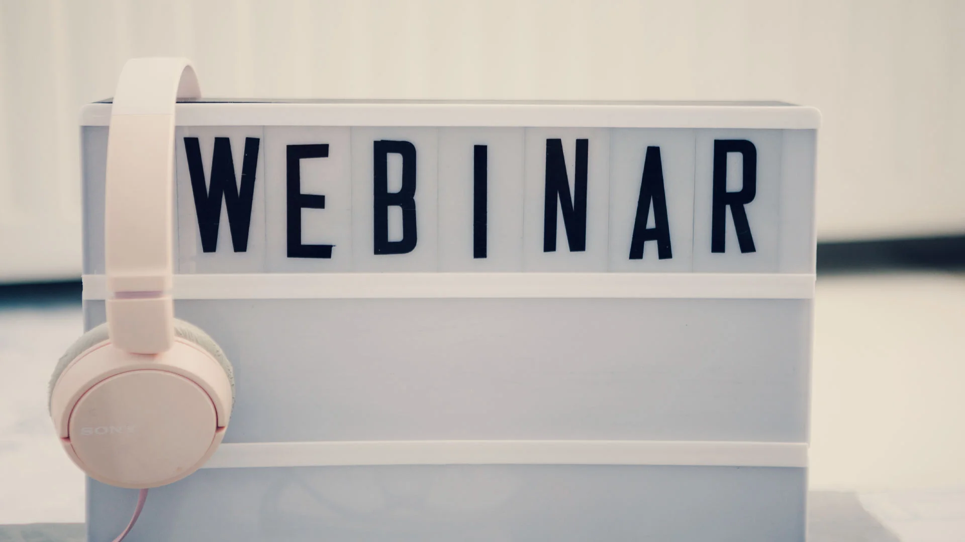 A set of headphones hanging on a sign that says webinar.