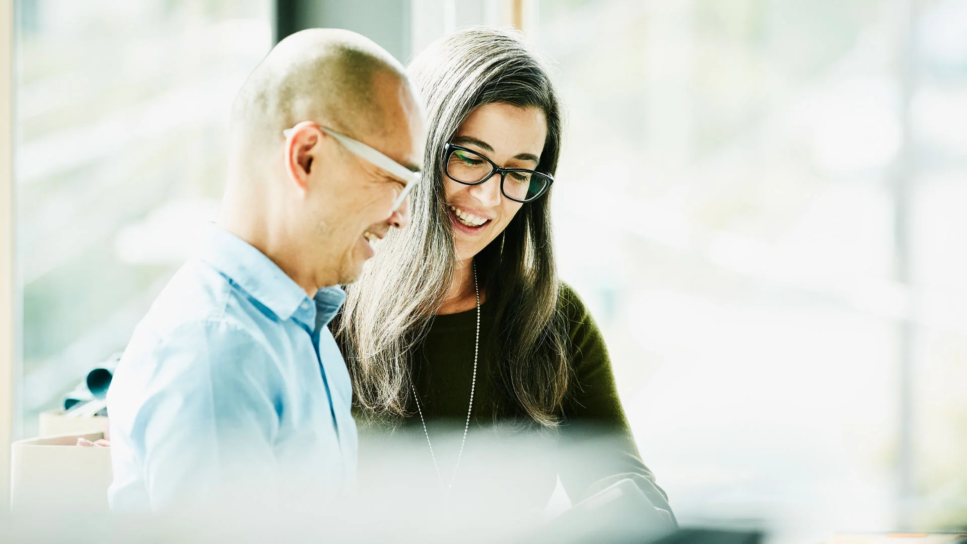 Two colleagues having an informal chat in an office.