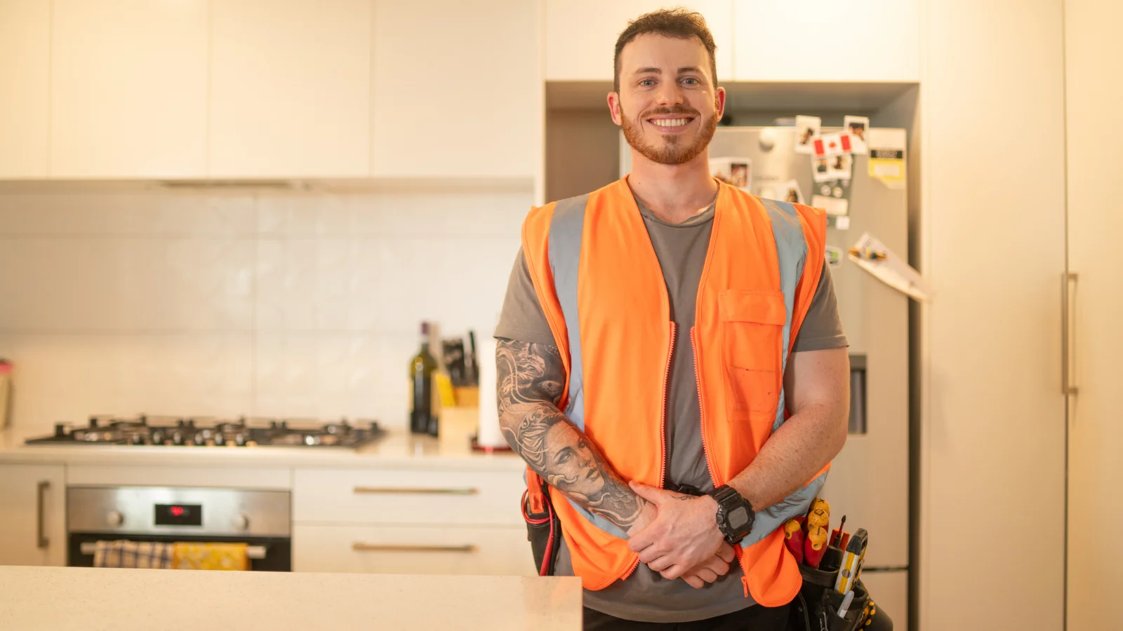 Builder's apprentice in kitchen with high vis on.