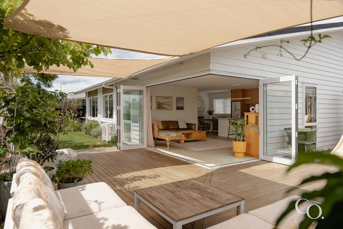 Bi-folding doors open out onto a sheltered wooden deck. 