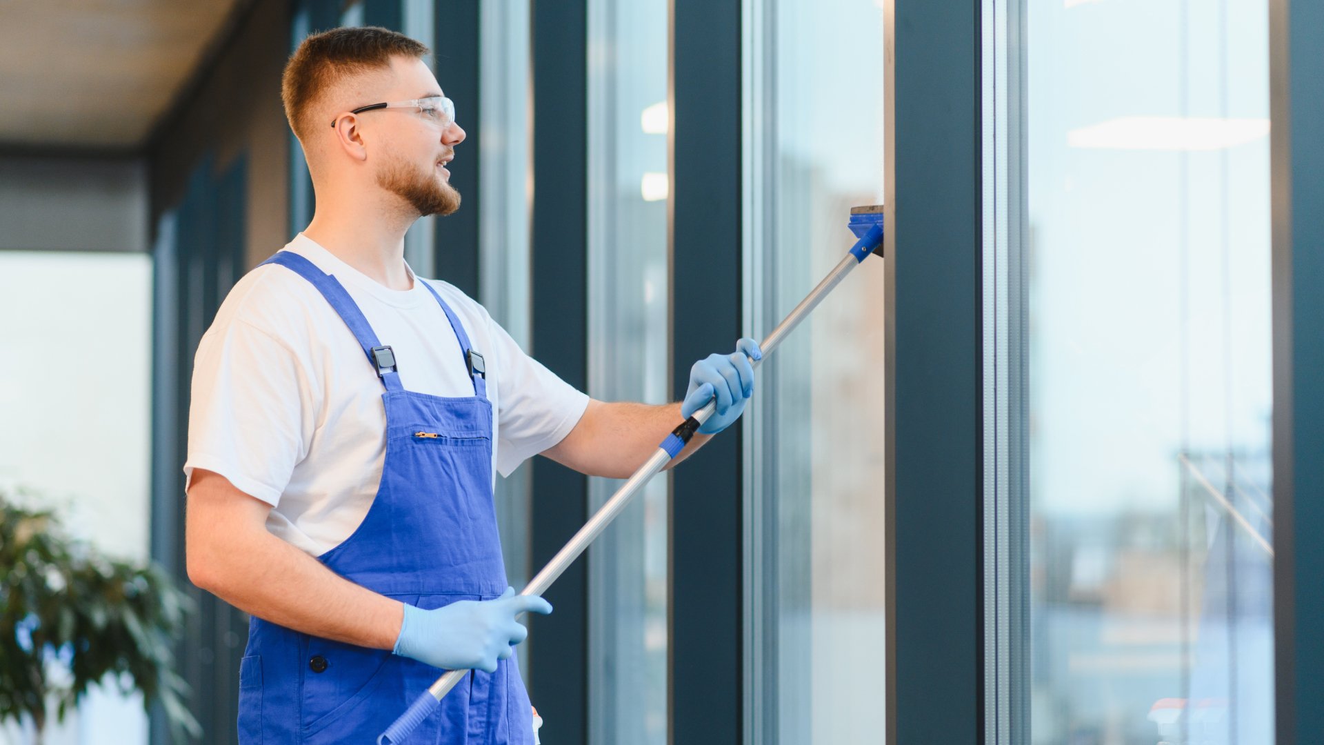 Male cleaner cleaning windows.