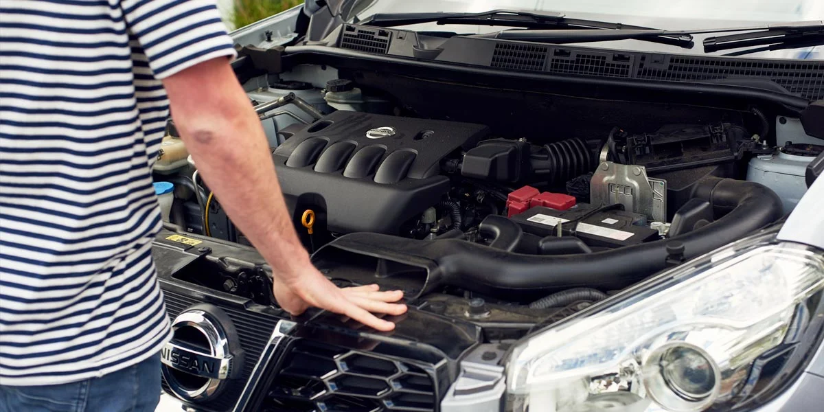 person checking car engine