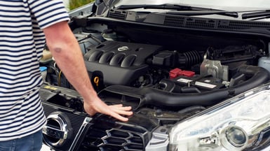 person checking car engine