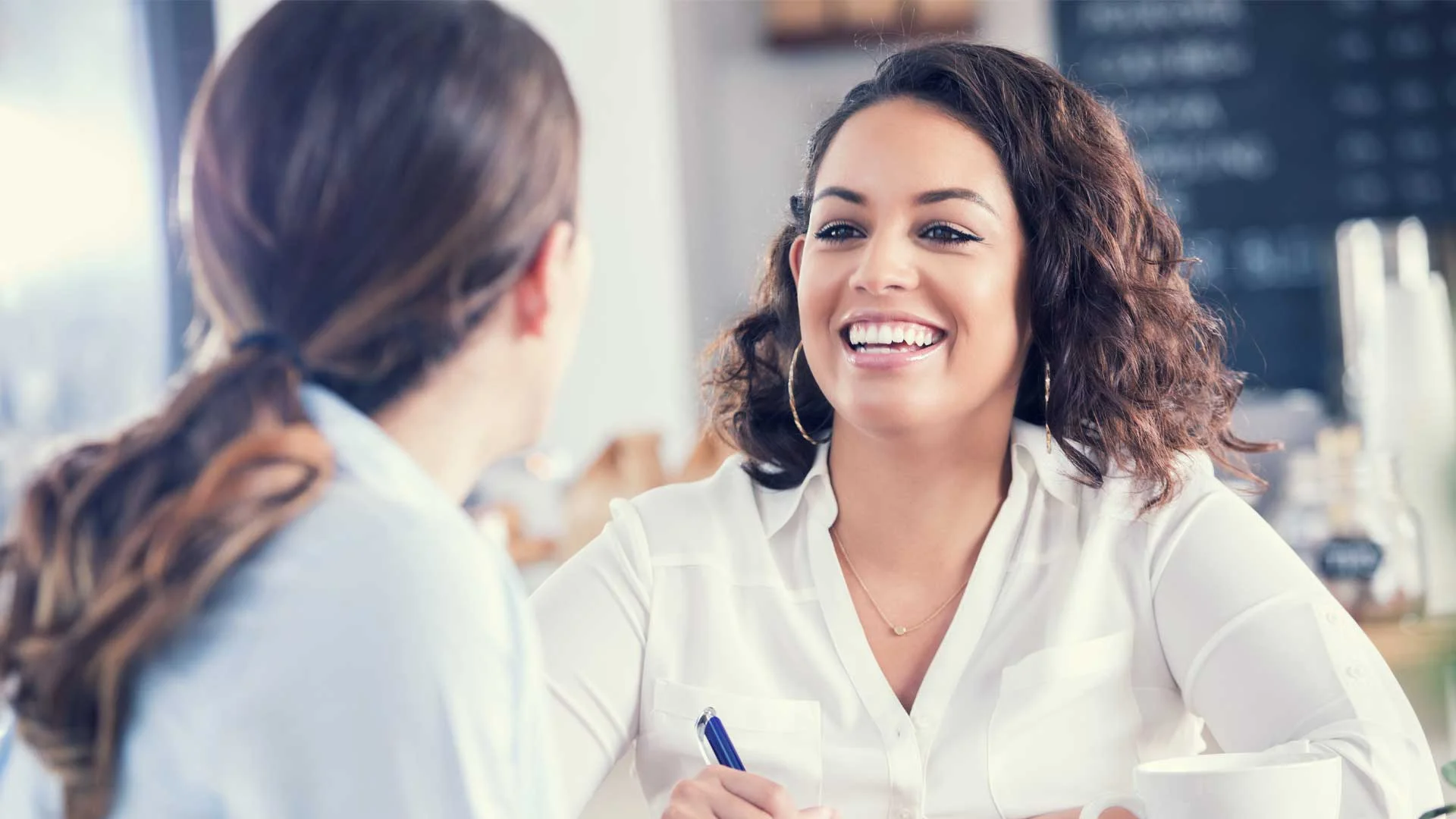 Friendly job interview taking place in a cafe.