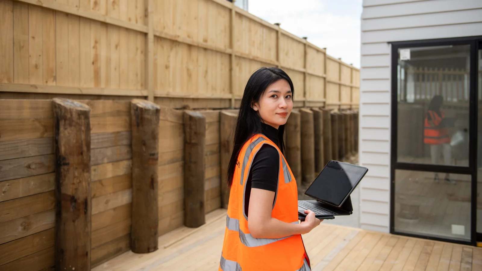 Female building inspector looking at new house with Ipad. 