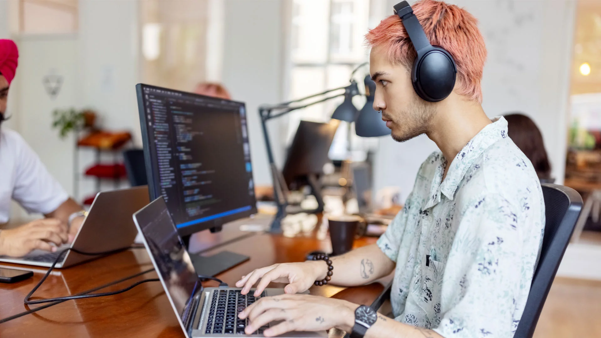 Young software engineer writing code on a computer at work.