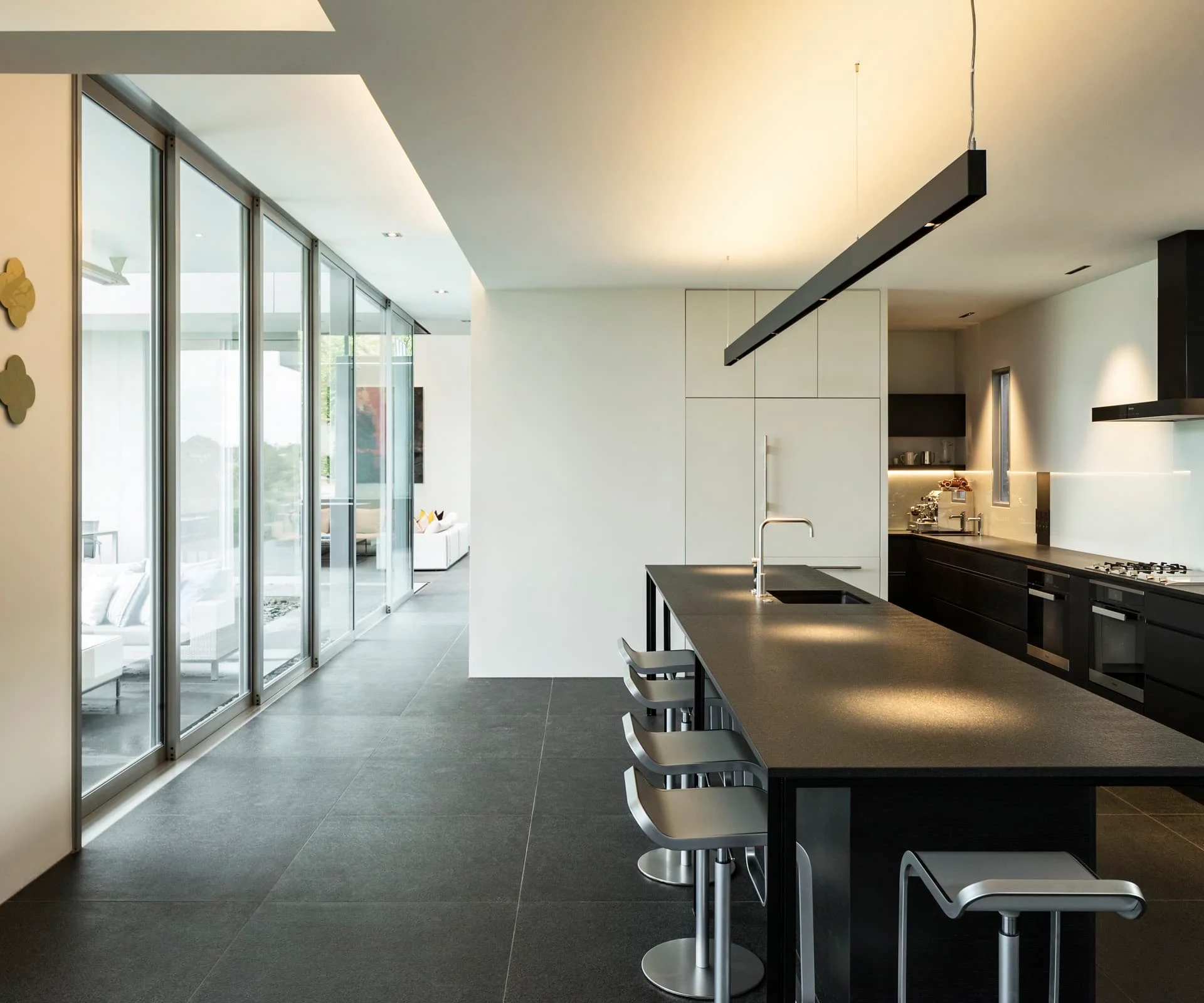 Modern black and white kitchen with a breakfast bar and bi-folding doors.