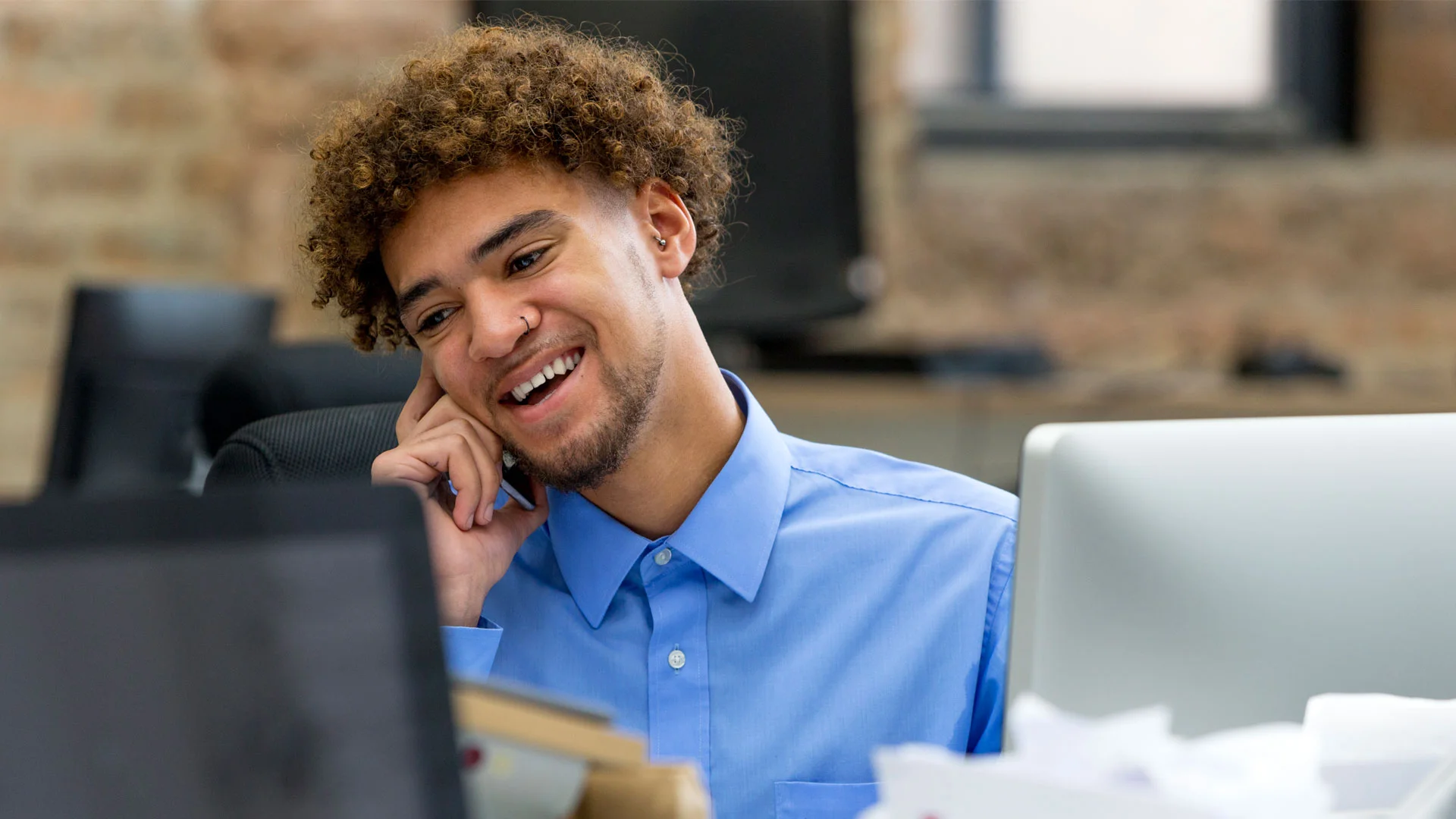 Young man working in an entry level receptionist job in New Zealand.