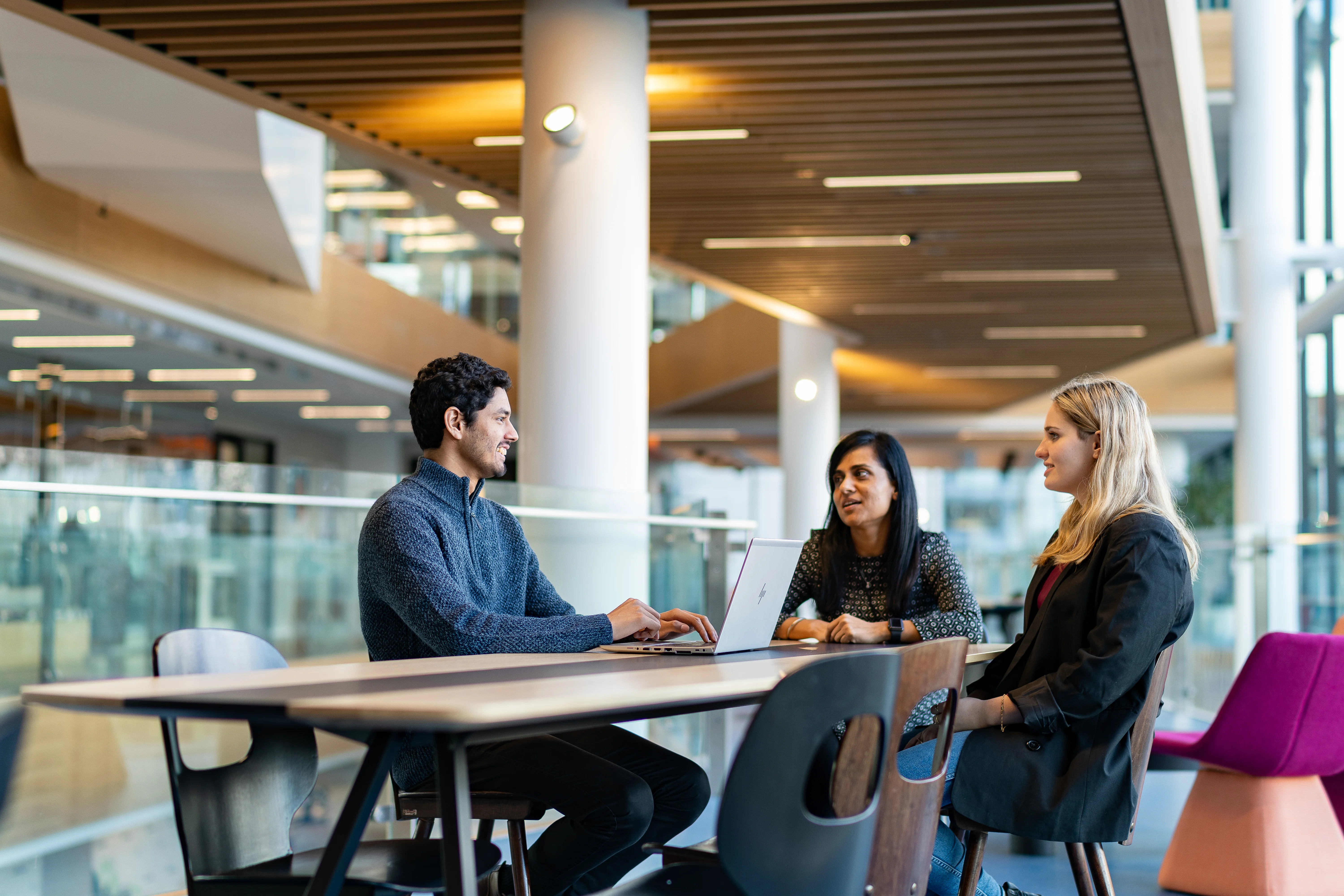 People conversing around a table in a professional setting.