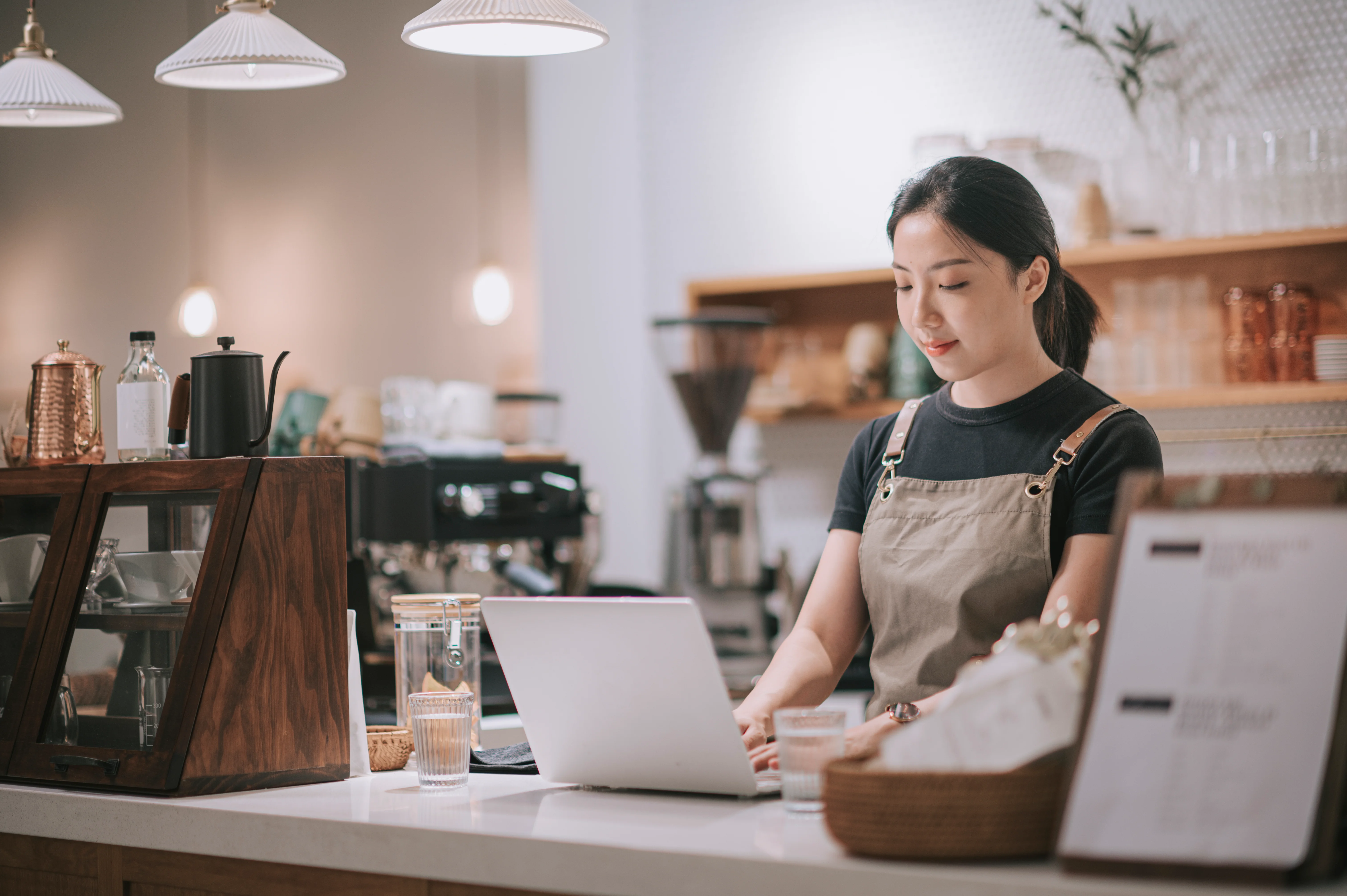 Young female employee working as a barista as a summer job.