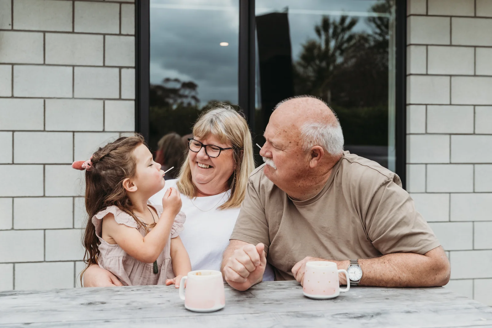 Grandparents have a cup of tea with their granddaughter 