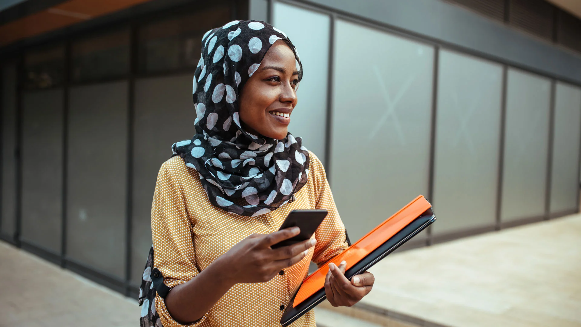 Female employee walking around her office block between meetings.
