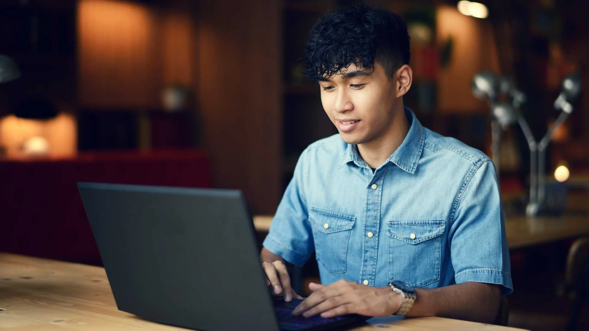Young man writing cover letter for rental property.