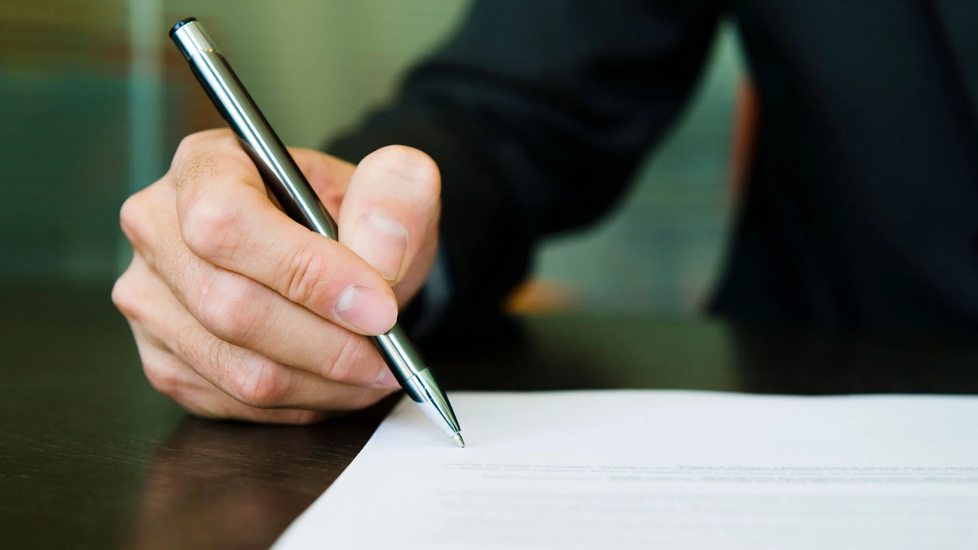A person signing the a sales and purchase agreement for a property in NZ.