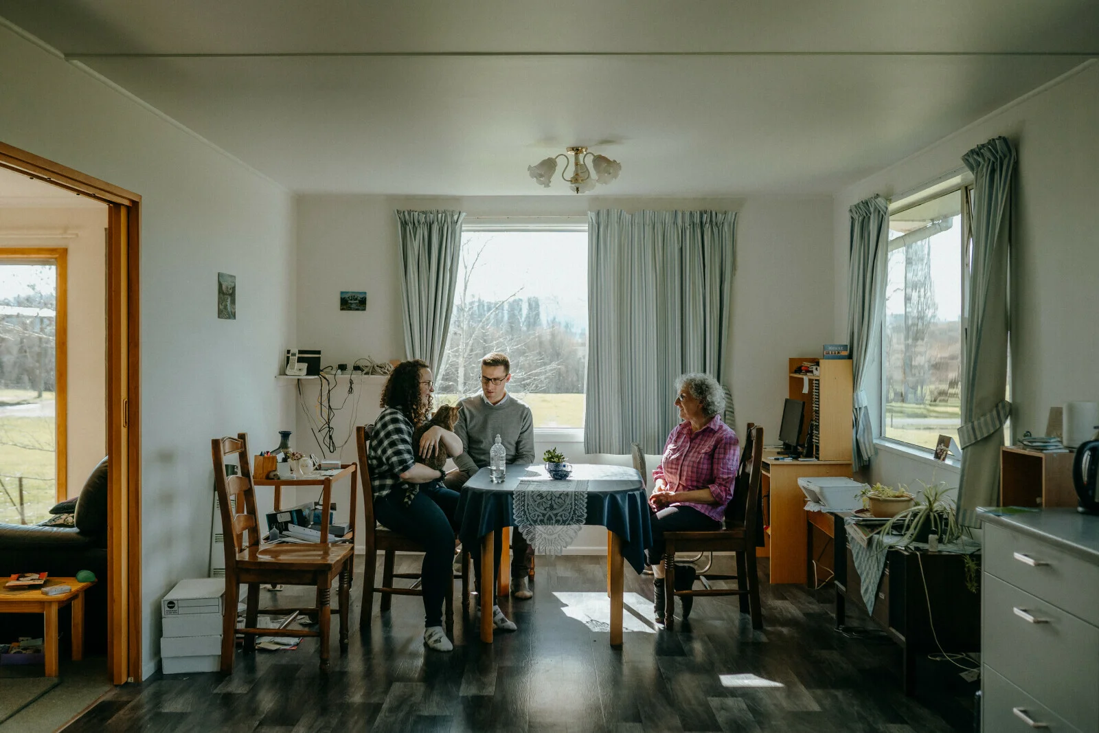 Whānau sit at their dining table