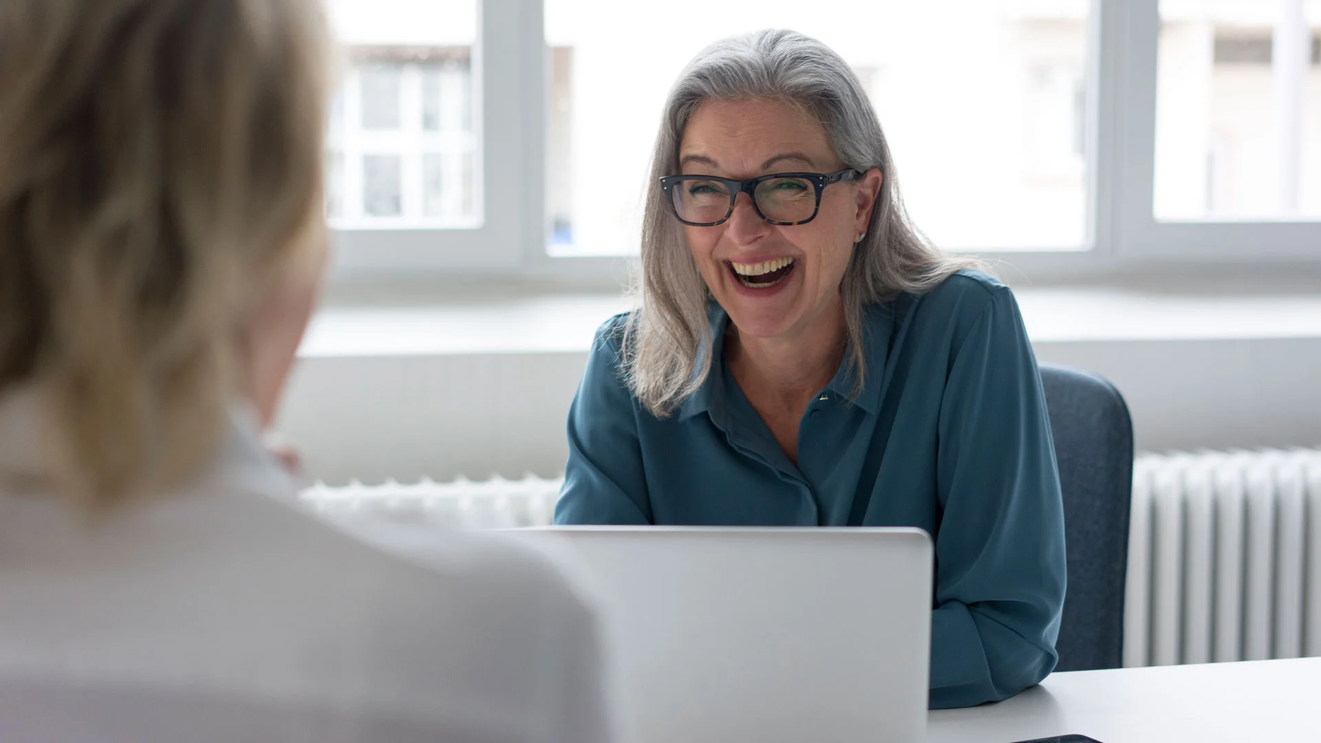Woman laughing in a job interview in New Zealand.