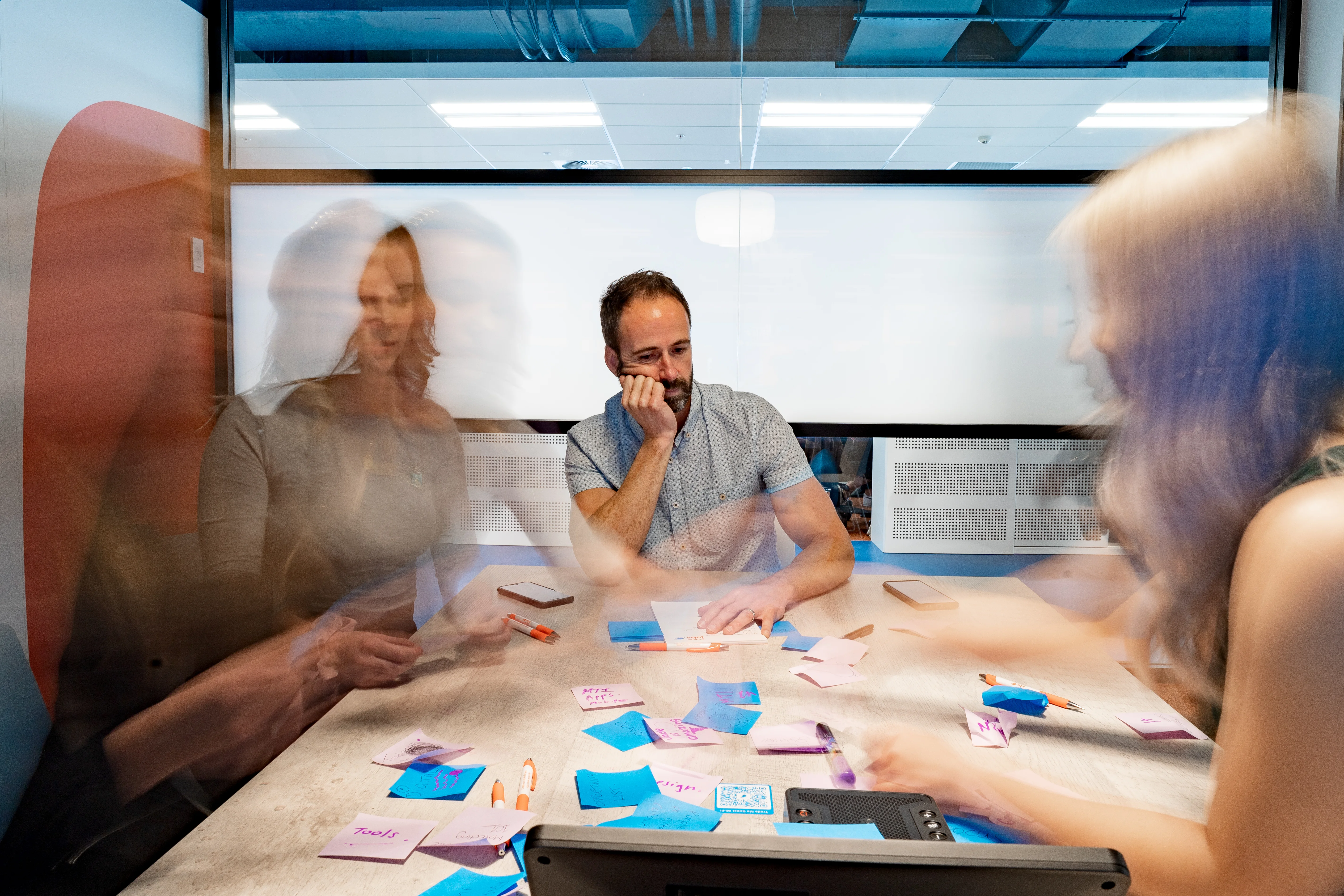 Man in group meeting appearing burnt-out.