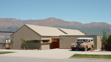 Outside of the home with a vintage car and blue skies