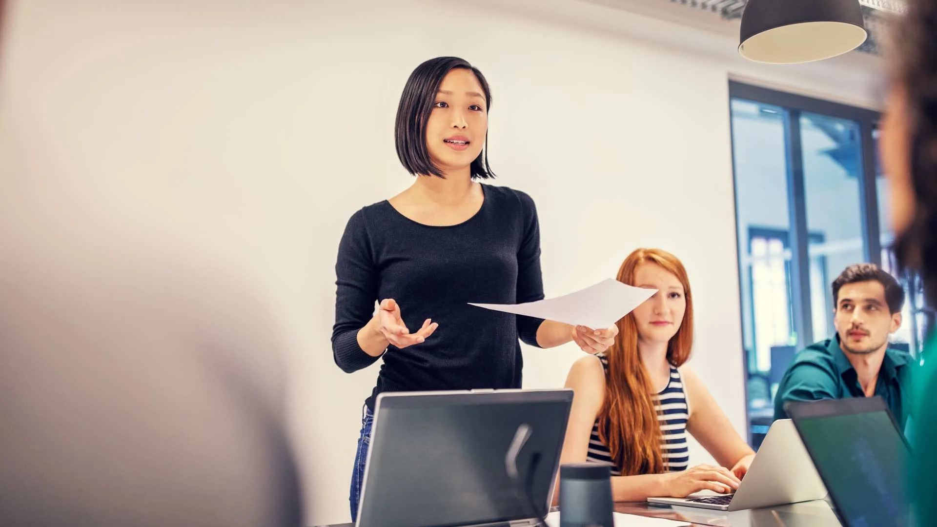 Employee presenting to her colleagues in a departmental meeting.