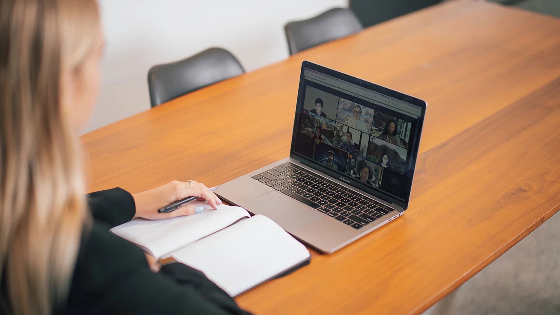 Woman working from home on her laptop, participating in a Zoom call with her team mates.