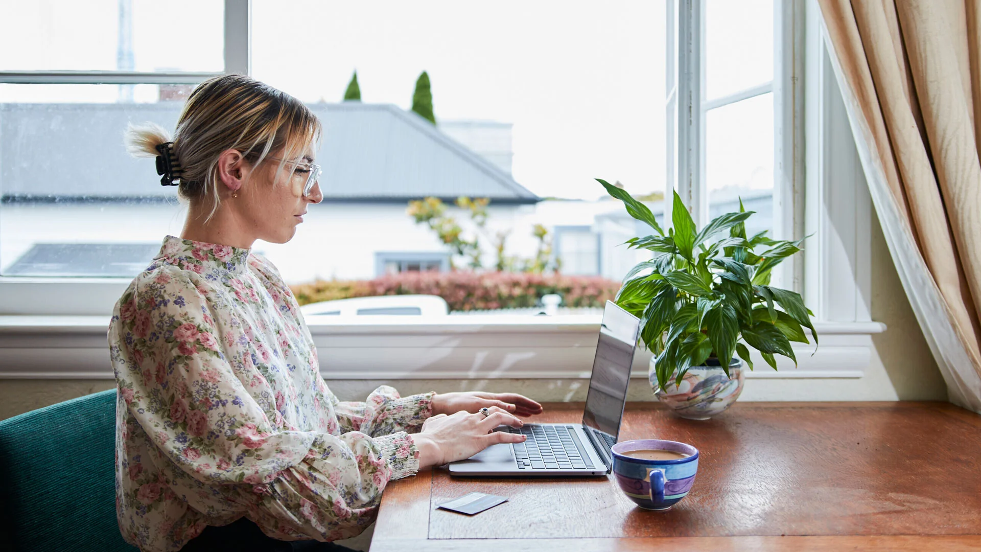Woman writing a cv on her laptop at home.