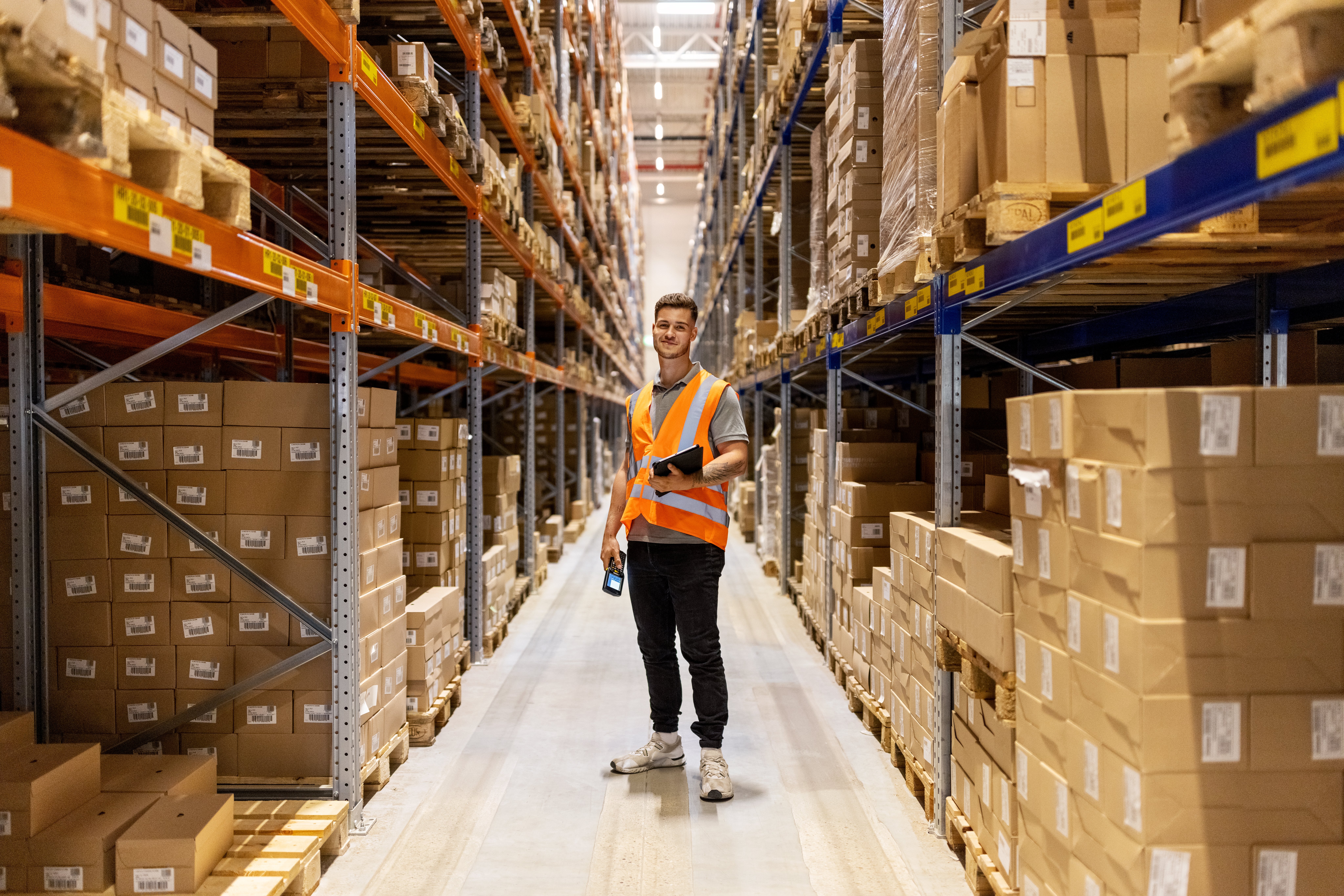 Young male warehouse worker standing inside a warehouse