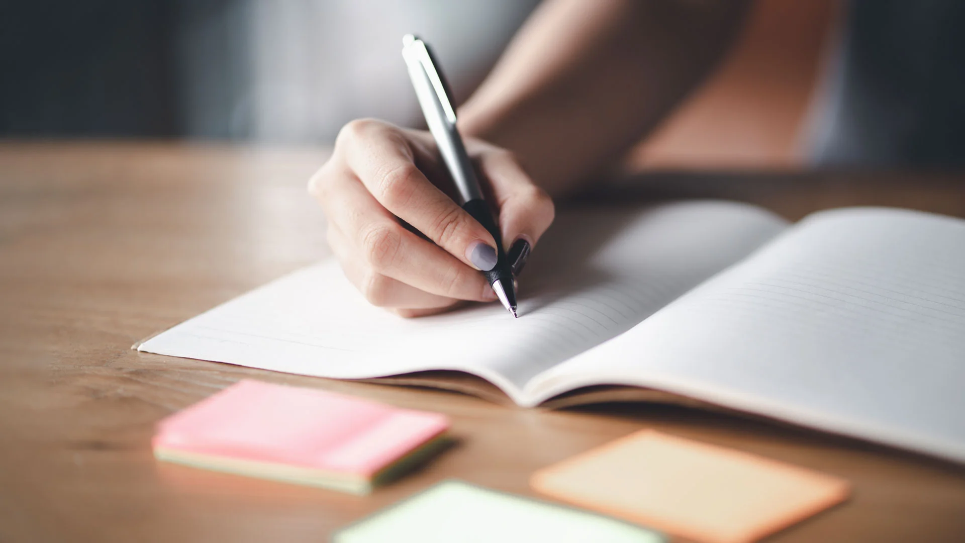 Employee planning a project with a notepad and sticky pads.