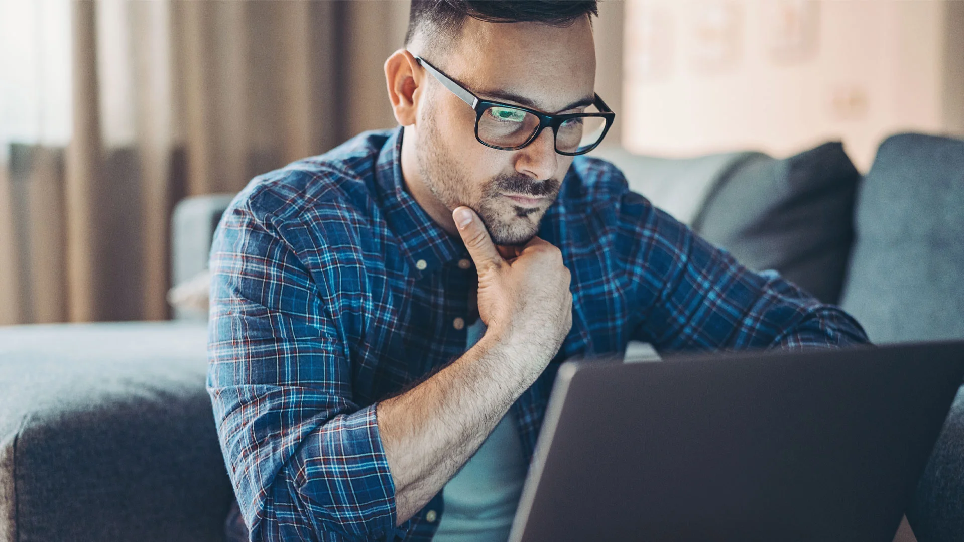 Man reading information about his new job in a laptop.