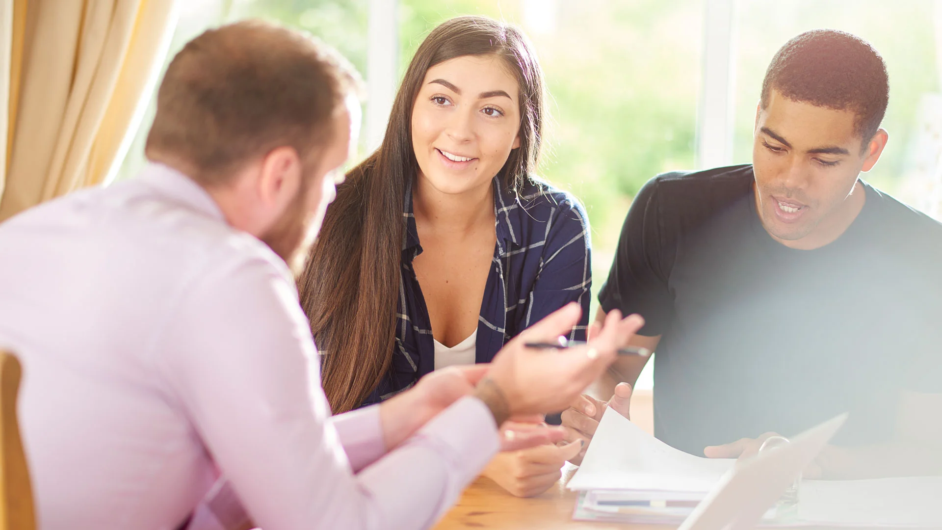 Landlord having a meeting with his tenants in the living room of the property.