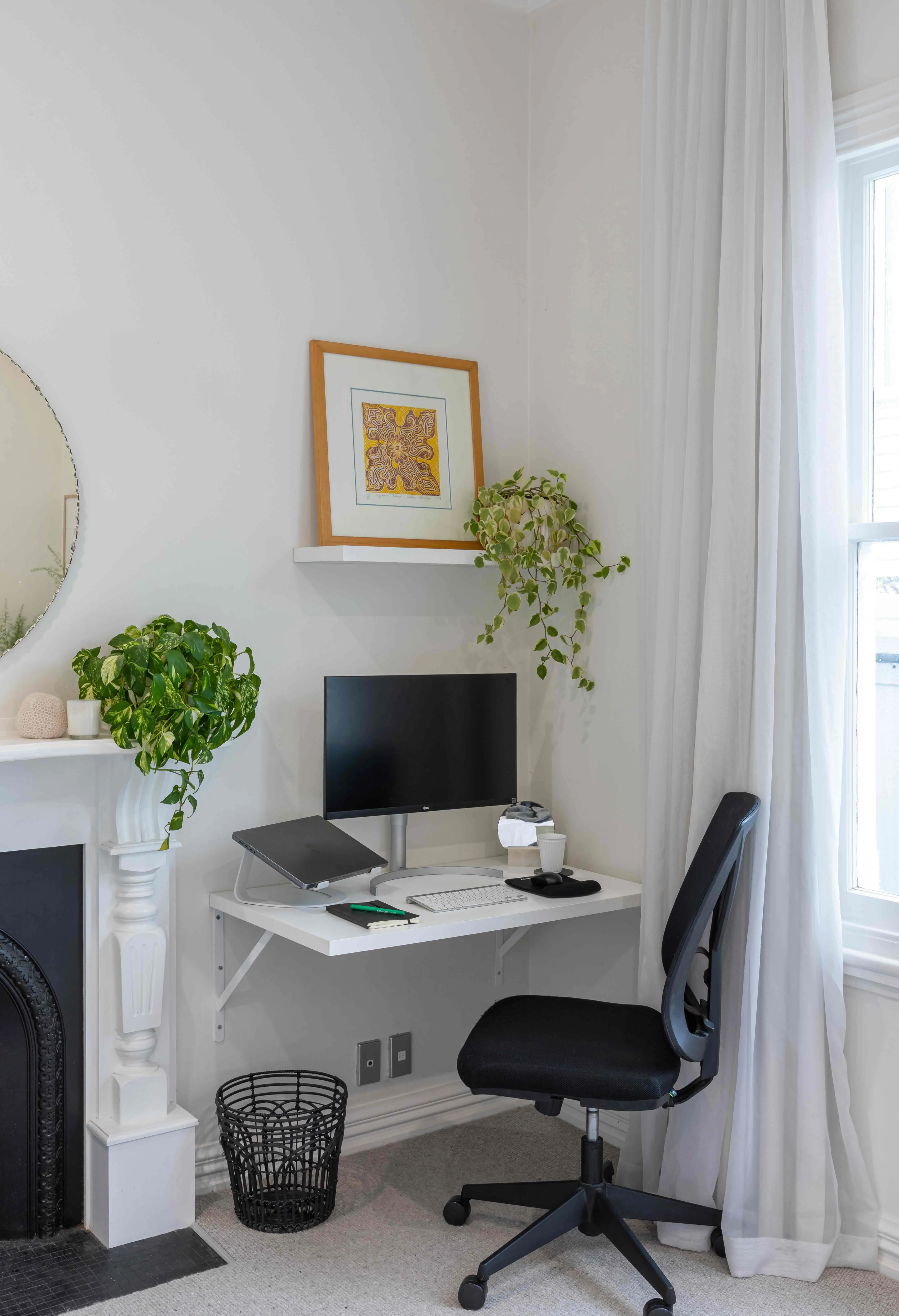 Greenery elevates the monochromatic palette of this simple home office. Image: John Williams