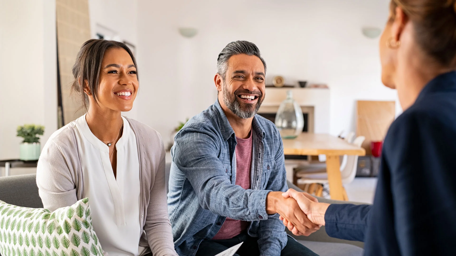 A couple meeting with a real estate agent to sell their home.