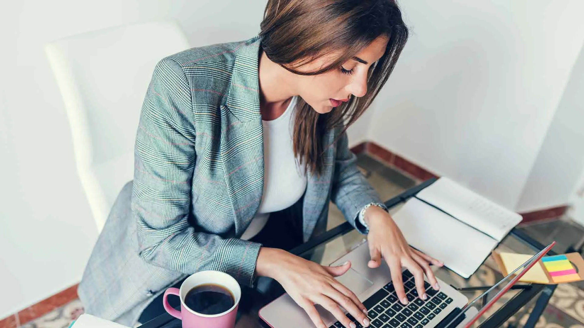 Woman writing resignation letter on her laptop.