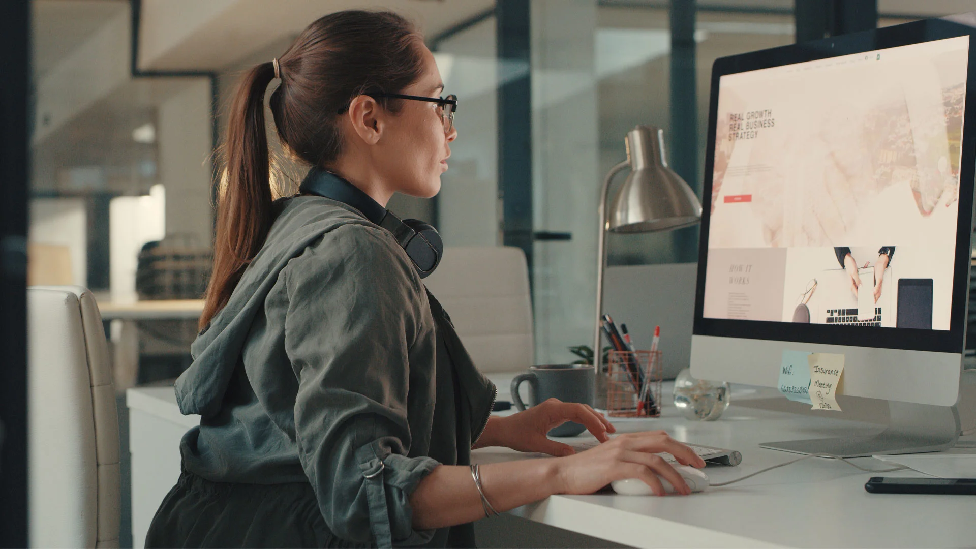 Female digital marketing employee working on a computer in an office.