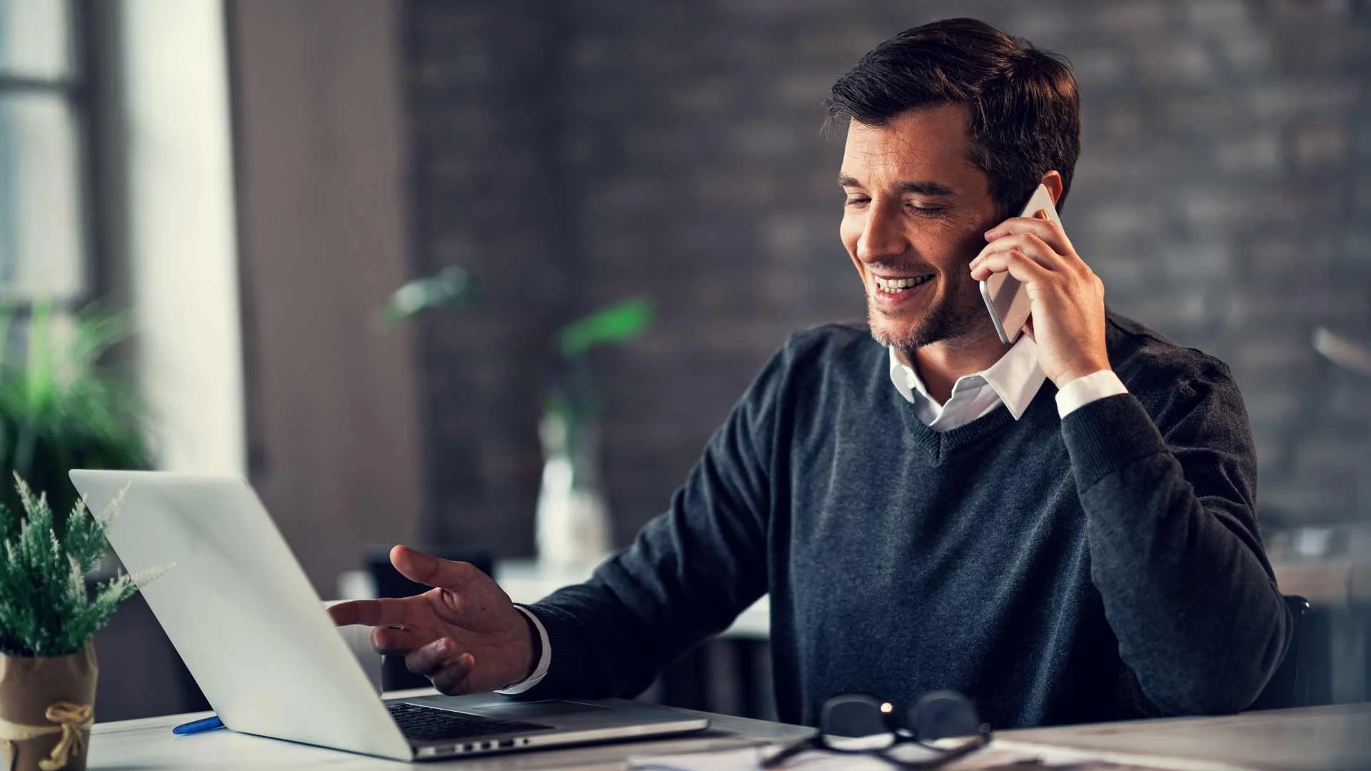 Applicant negotiating his salary on the phone with the employer in an office.