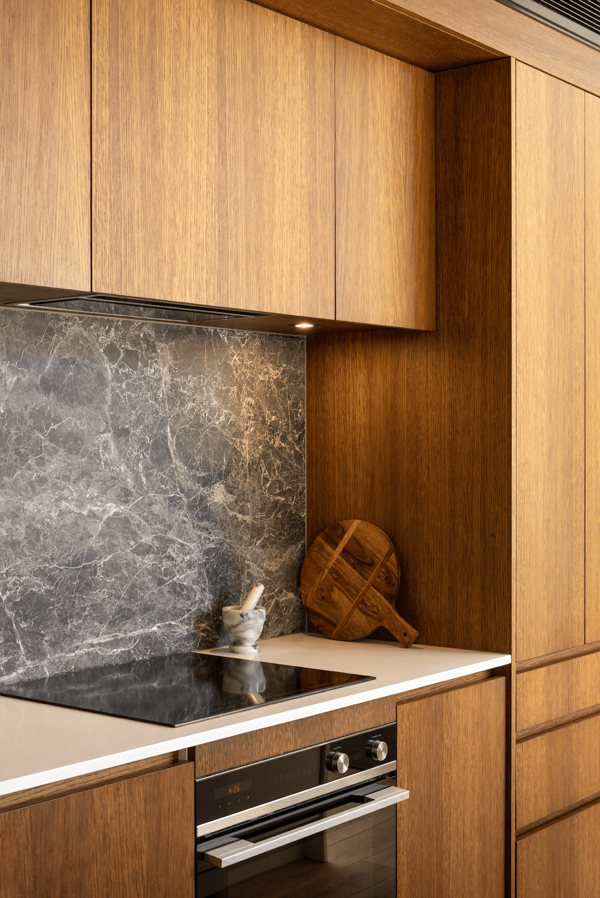 The white and marble backdrop by the kitchen hob is really pulled out by the wood on the kitchen cupboards
