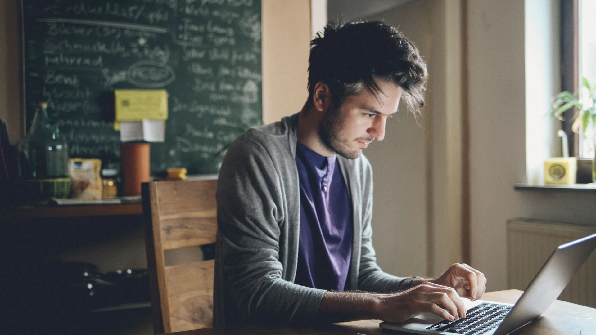 Freelance writing working on his laptop in a cafe.