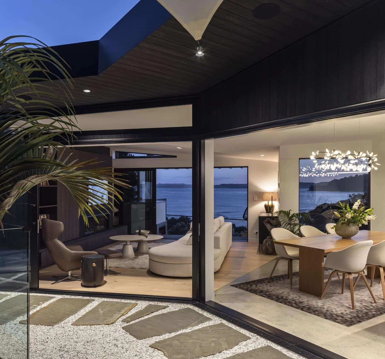 Lounge in the 2023 Readers’ Choice Home of the Year by Matter Architects, featuring a sculptural couch and open outdoor views. Furniture by Bo Concept.