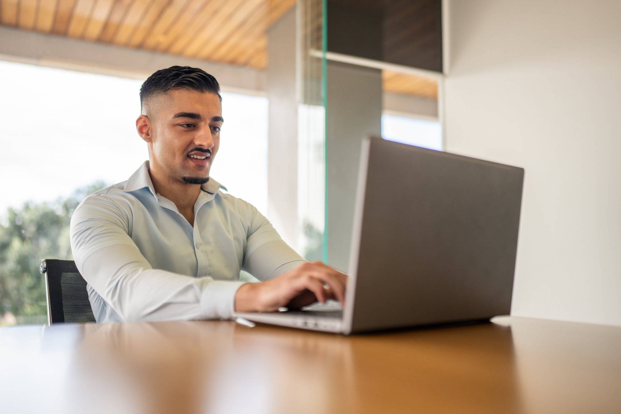 Young male real estate agent sitting at computer